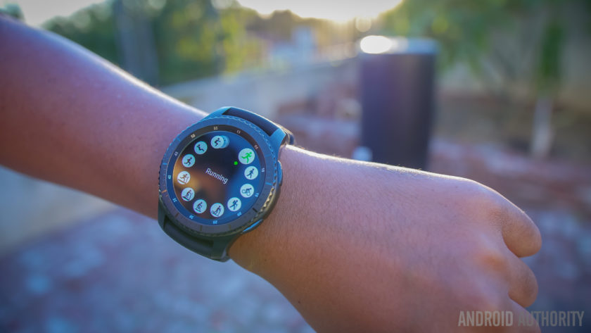  smartwatch سامسونگ S3 دنده بر روی مچ دست در پارک در غروب آفتاب. 