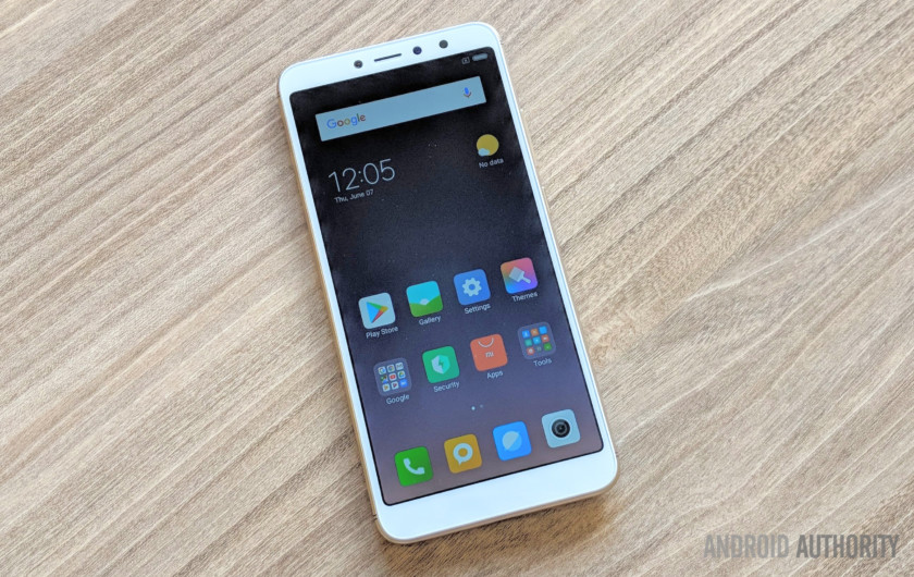 Xiaomi Redim Y2 گوشی سفید، چهره کردن را روی میز چوبی را. 