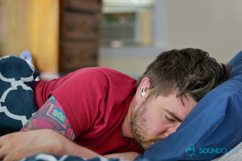  عکس از کریس در تخت خواب در حالی که با استفاده از Sleepbuds بوز نزدیک کولر. 